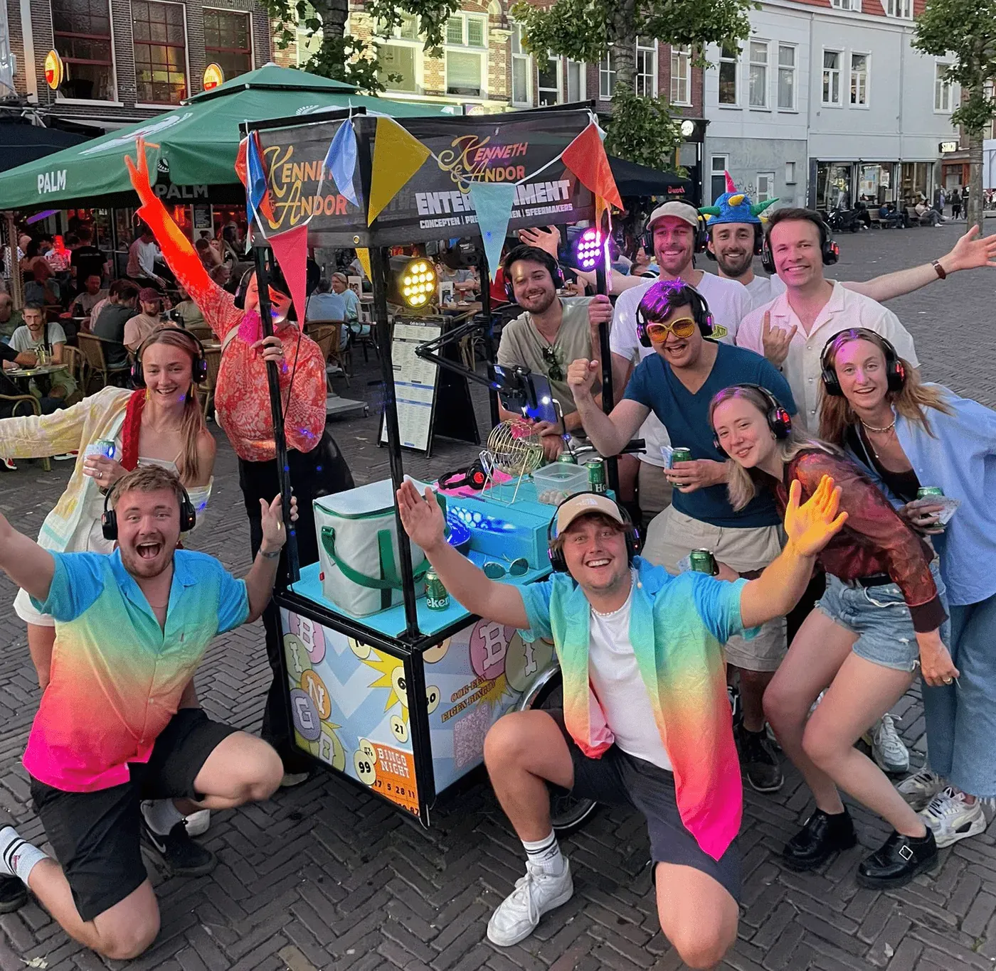 Groep gasten juicht rond de Bingobakfiets tijdens een straatfeest