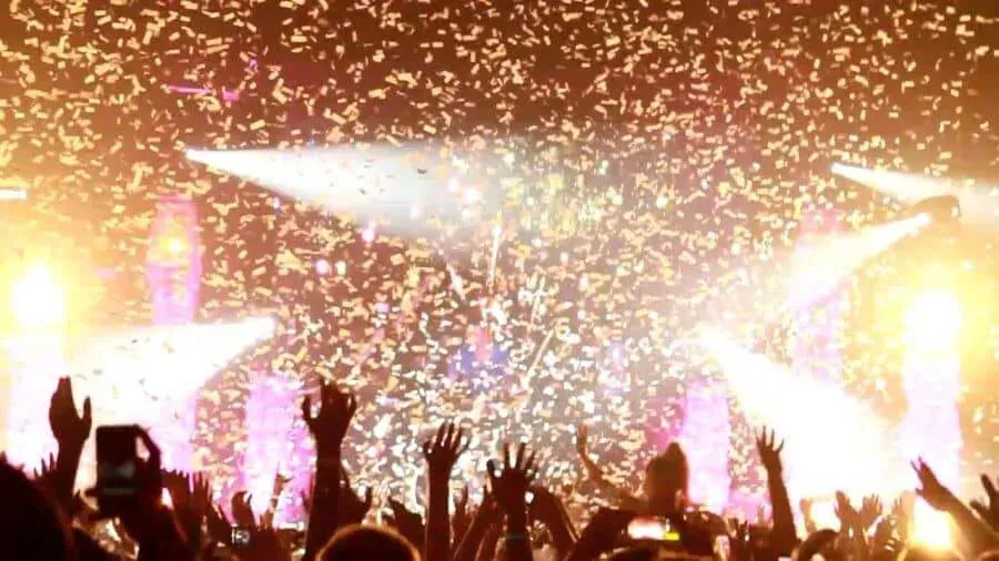 Gouden confetti valt door de lichtbundels boven een juichende zaal