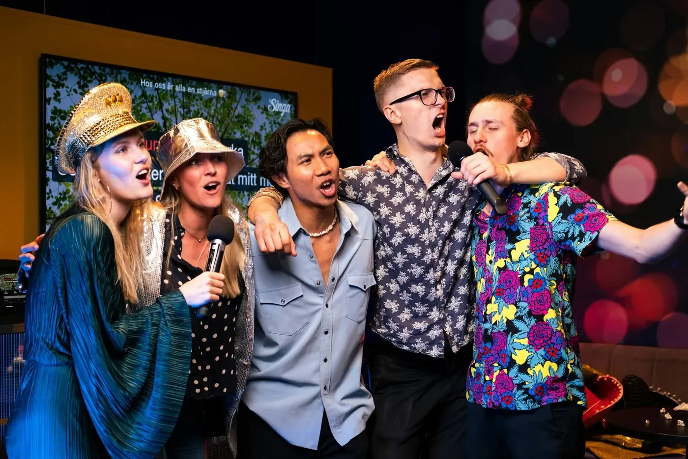 Groep collega's zingt samen met microfoons tijdens de karaokeshow