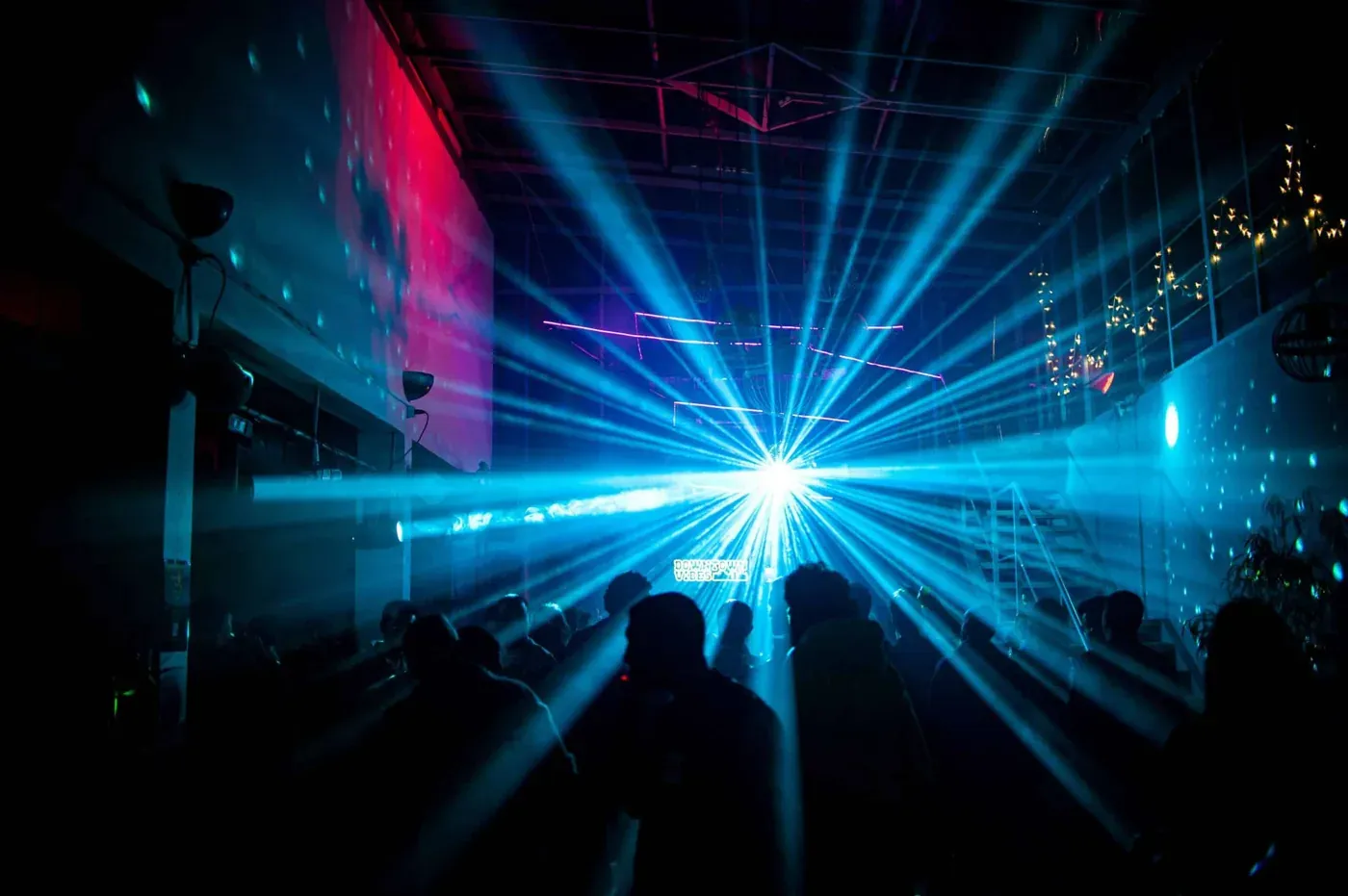 Blauwe laserstralen door een zaal tijdens een show